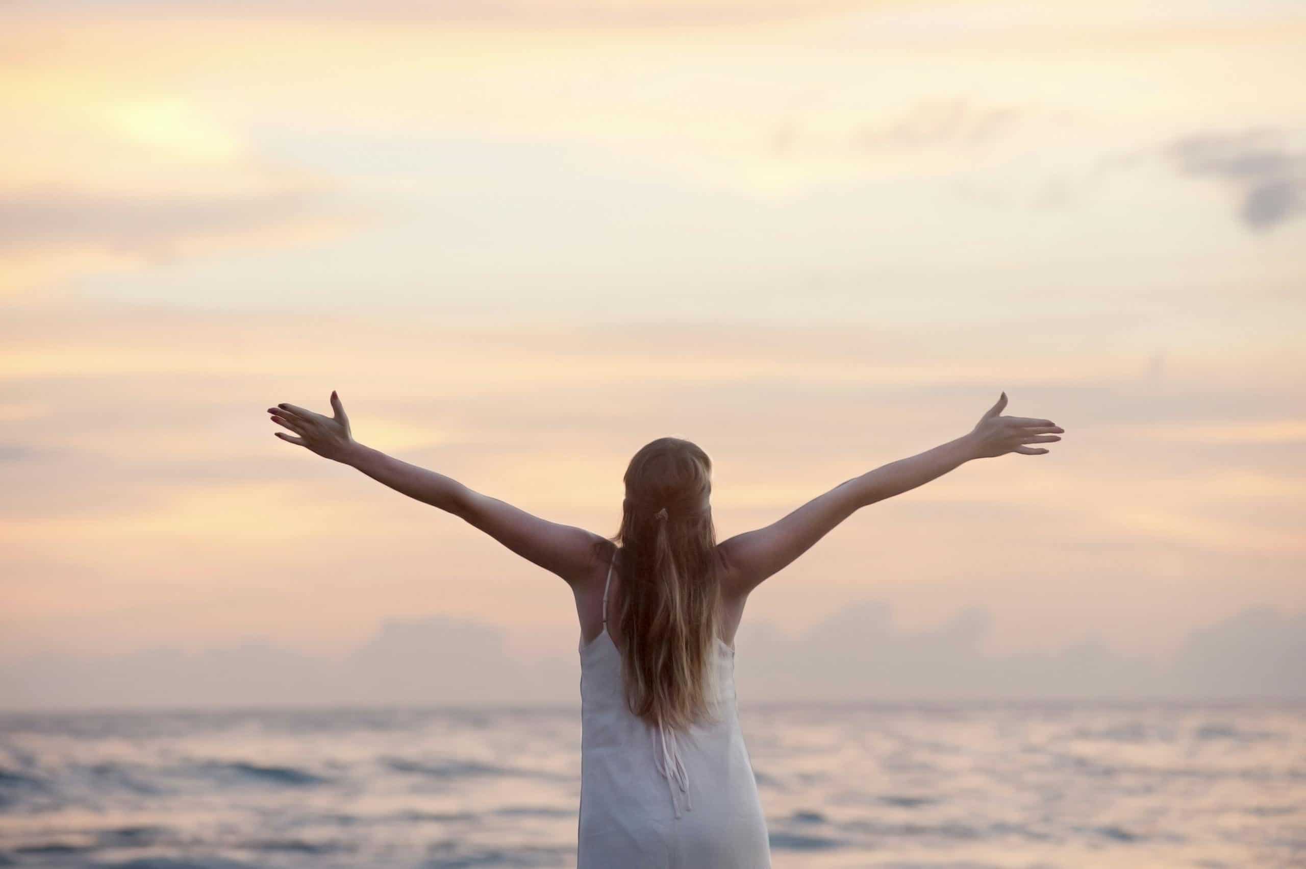A woman enjoying a serene sunset on Unawatuna Beach, Sri Lanka, depicting boosting your mood and raising your vibration.