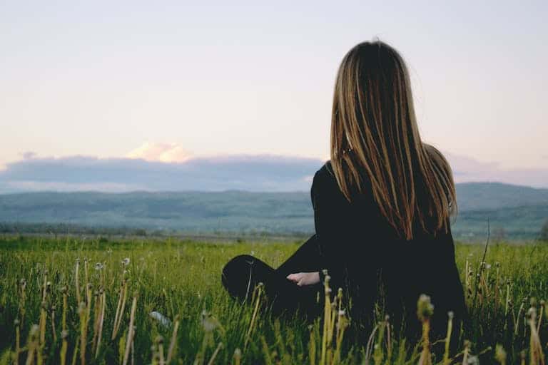 Woman enjoying being present in the moment looking at nature.