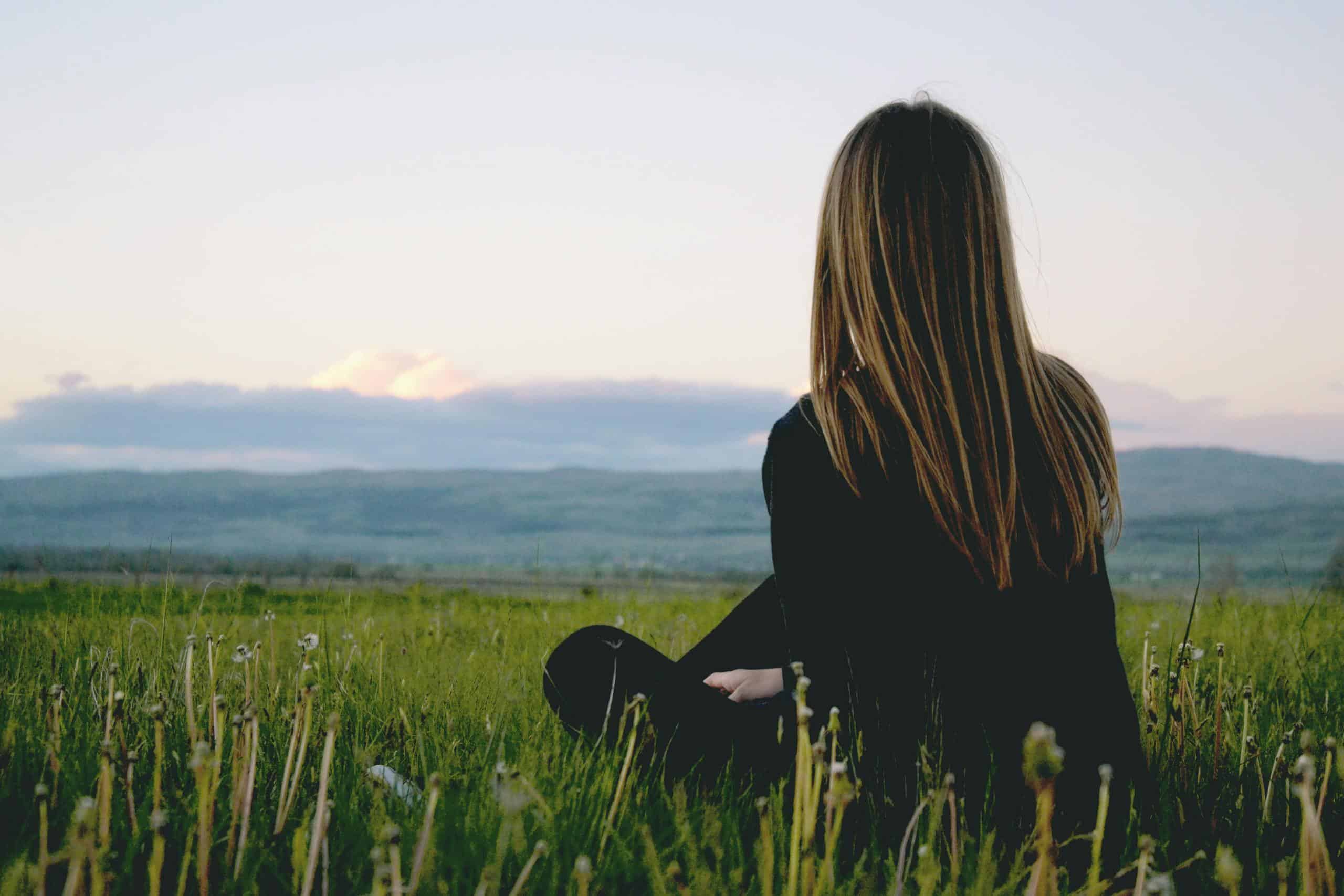 Woman enjoying being present in the moment looking at nature.