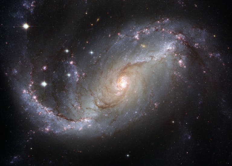 Capture of the NGC 1672 spiral galaxy showcasing its majestic spiral arms and bright core representing the 12 Universal Laws.