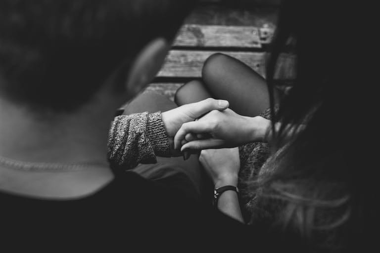 A couple holding hands, symbolising caring for yourself while supporting a loved one who is suffering from mental health and suicidal thoughts.
