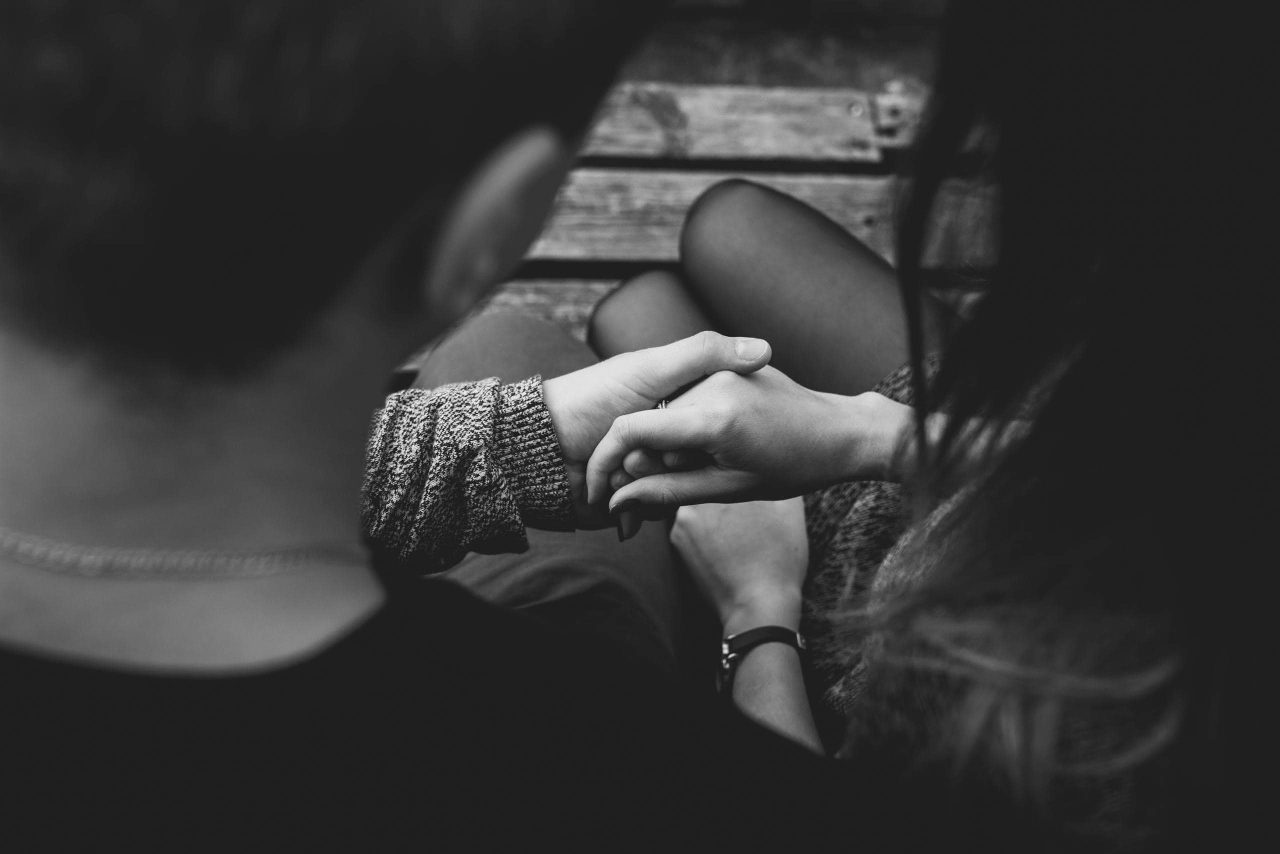 A couple holding hands, symbolising caring for yourself while supporting a loved one who is suffering from mental health and suicidal thoughts.