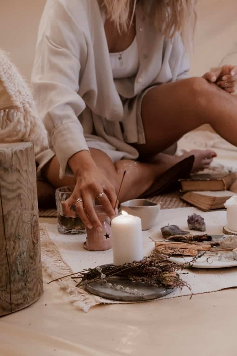 Cozy indoor scene of relaxation with candles, crystals, and incense to represent your healing journey.